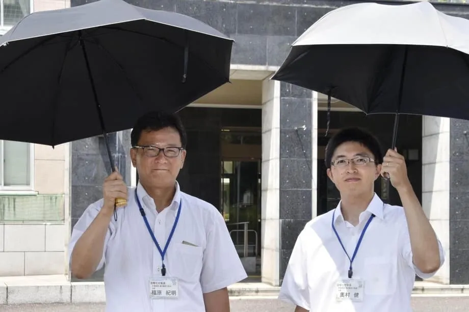 Di tengah teriknya cuaca di Jepang, pria beralih menggunakan payung peneduh agar tetap sejuk